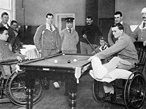Recuperating: Wounded soldiers playing billiards from invalid chairs, WW1