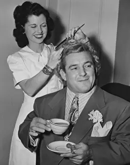 Hair Dresser: Wrestler Gorgeous George holding a tea cup as his