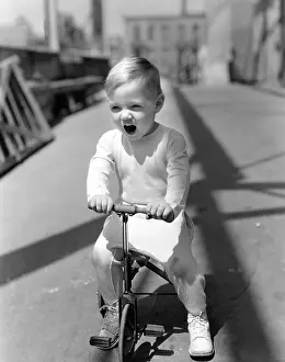Preschool: Yawning boy riding tricycle