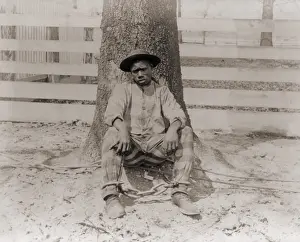 Enslavement: Young African American sitting with legs ?