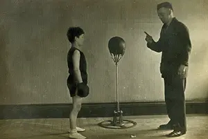 Punchbag: Young Boxer receiving instruction from his Trainer in a gym