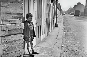 Boarded: Young boy in front of boarded up buildings