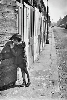 Boarded: Young boy in front of boarded up buildings