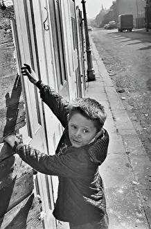 Boarded: Young boy in front of boarded up buildings