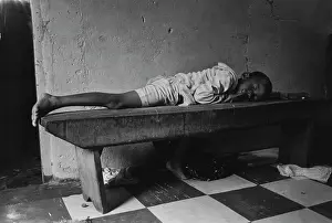 Katlehong: Young boy resting on a bench in Katlehong