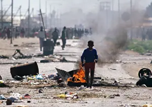 Littered: A young boy stand in front of a smoky tyre fire