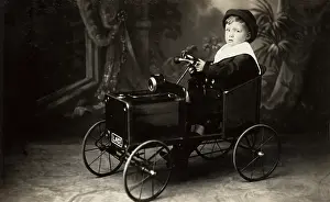 Numberplate: Young boy in toy car
