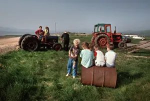 Pals: Young children play and men work on tractors - Askam, Cumbria