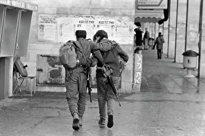 A young couple, in military uniform, with guns