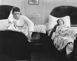 Argue: Young couple in separate beds after fight