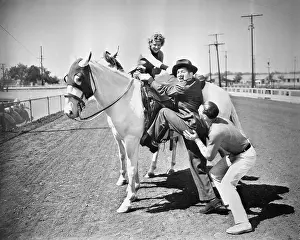 Anxiety: Young couple trying to help a man get onto his horse