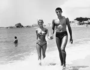 Blanes: Young couple walking along a beach, Spain