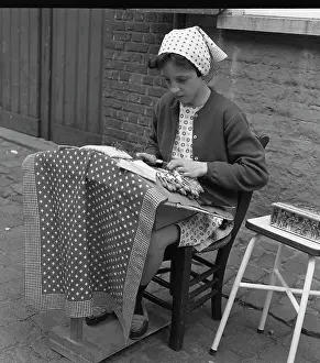 Lacemaking: Young girl making lace on the pavement