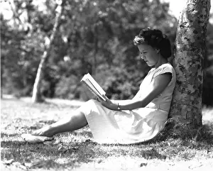 Camerique: Young girl sitting under a tree reading