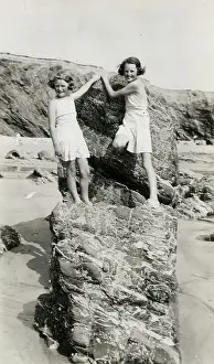 Climbs: Two young girls playing on the rocks on a Cornish beach