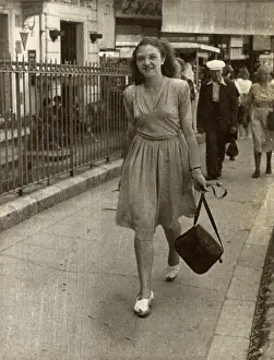 Confidently: Young lady strolling confidently along, swinging her handbag