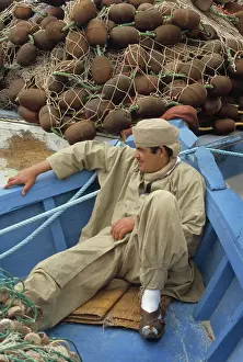 Harbourside: Young man in boat, Tunisia