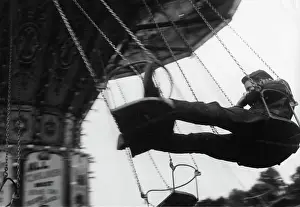 Nonchalantly: Young man on chain swing fairground ride