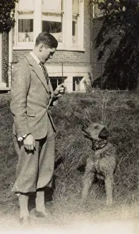 Tweedy: Young man with a dog in a garden