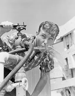 Purity: Young man drinking water from hose