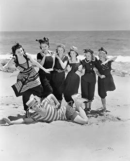 Flirtatious: Young man with a group of young women at the beach
