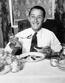 Shaker: Young man having breakfast and smiling