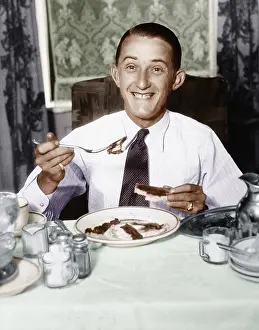 Shaker: Young man having breakfast and smiling