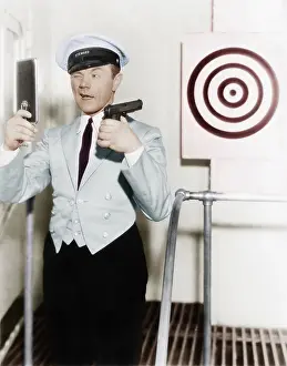 Perseverance: Young man looking at a mirror and aiming at a dartboard