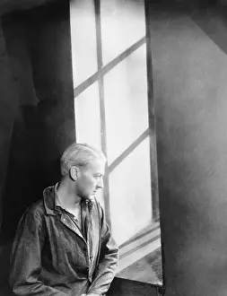 Lamenting: Young man looking through a window