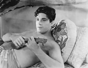 Ponder: Young man lying on the bed and playing a guitar