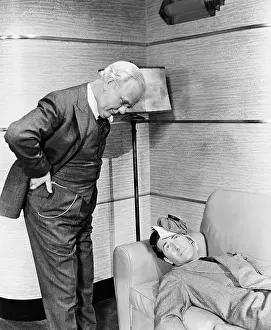 Lamenting: Young man lying on a couch with a man looking at him