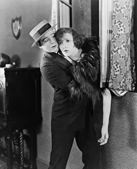 Lamenting: Young man pulling a young woman from a window
