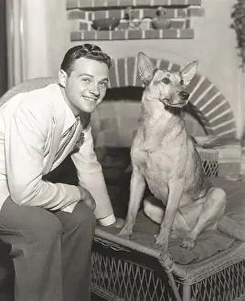 Obedient: Young man sitting with dog at home