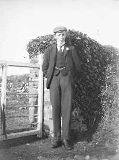 Buttonhole: Young man standing by a gate