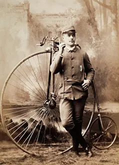 Costumed: Young man in uniform with a pennyfarthing bicycle