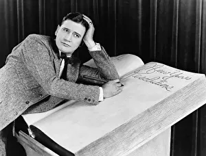 Decisions: Young man writing into an oversized note book