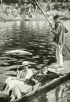 Punting: Three young people punting on a river, England