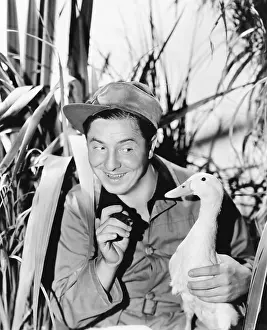Witty: Young smiling man holding a duck