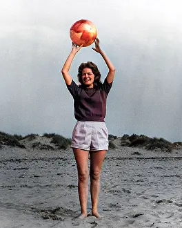 Andrew Besley: Young woman with ball on beach
