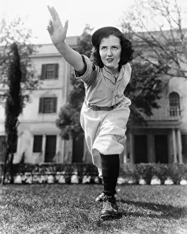 Pitching: Young woman in baseball uniform throwing a ball