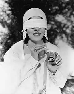 Eyeball: Young woman with blindfolded eyes taking out a cigarette