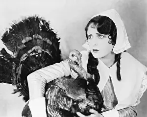 Safeguard: Young woman in a bonnet hugging a turkey