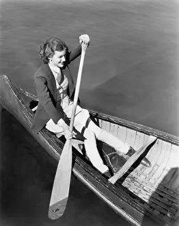 Canoeing: Young woman in a canoe rowing