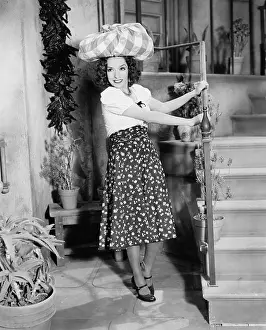 Sneaky: Young woman carrying a bundle on her head and smiling