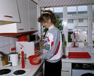 Drainer: Young woman cooking in a kitchen