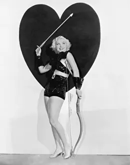 Heart Shaped: Young woman dressed up as cupid standing in front