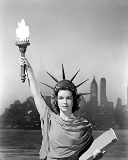 Waist Up: Young woman dressed as the Statue Of Liberty with