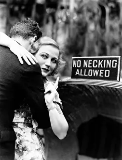 Cautious: Young woman embracing a man and pointing towards