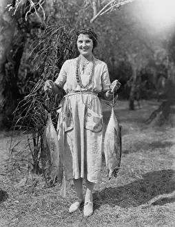 Rareness: Young woman holding two huge fish