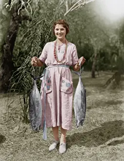 Rareness: Young woman holding two huge fish